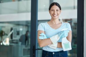 Maid services in Manhattan. Cleanzilla maid wearing blue gloves and holding a cleaning solution spray bottle